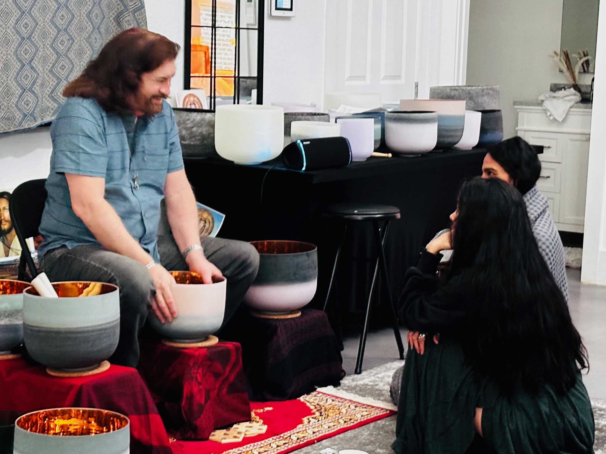 Dr. Paul Hubbert demonstrating a crystal singing bowl with participants gathered nearby