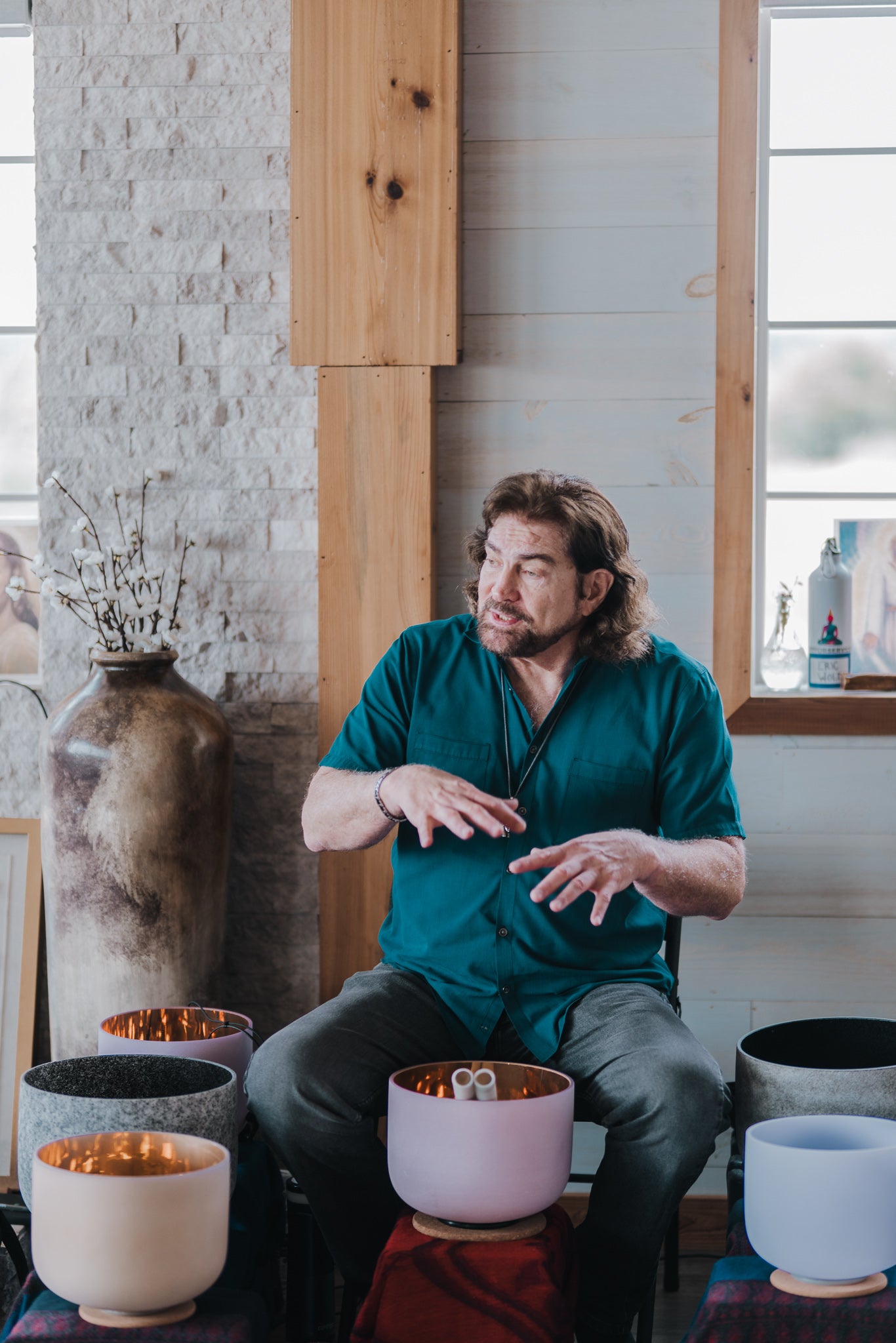 Dr. Paul Hubbert seated with crystal singing bowls
