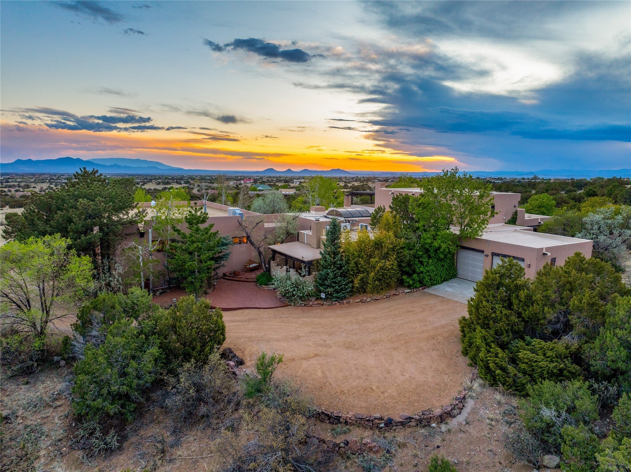 The ranch and surrounding land beneath a dramatic New Mexico sunset