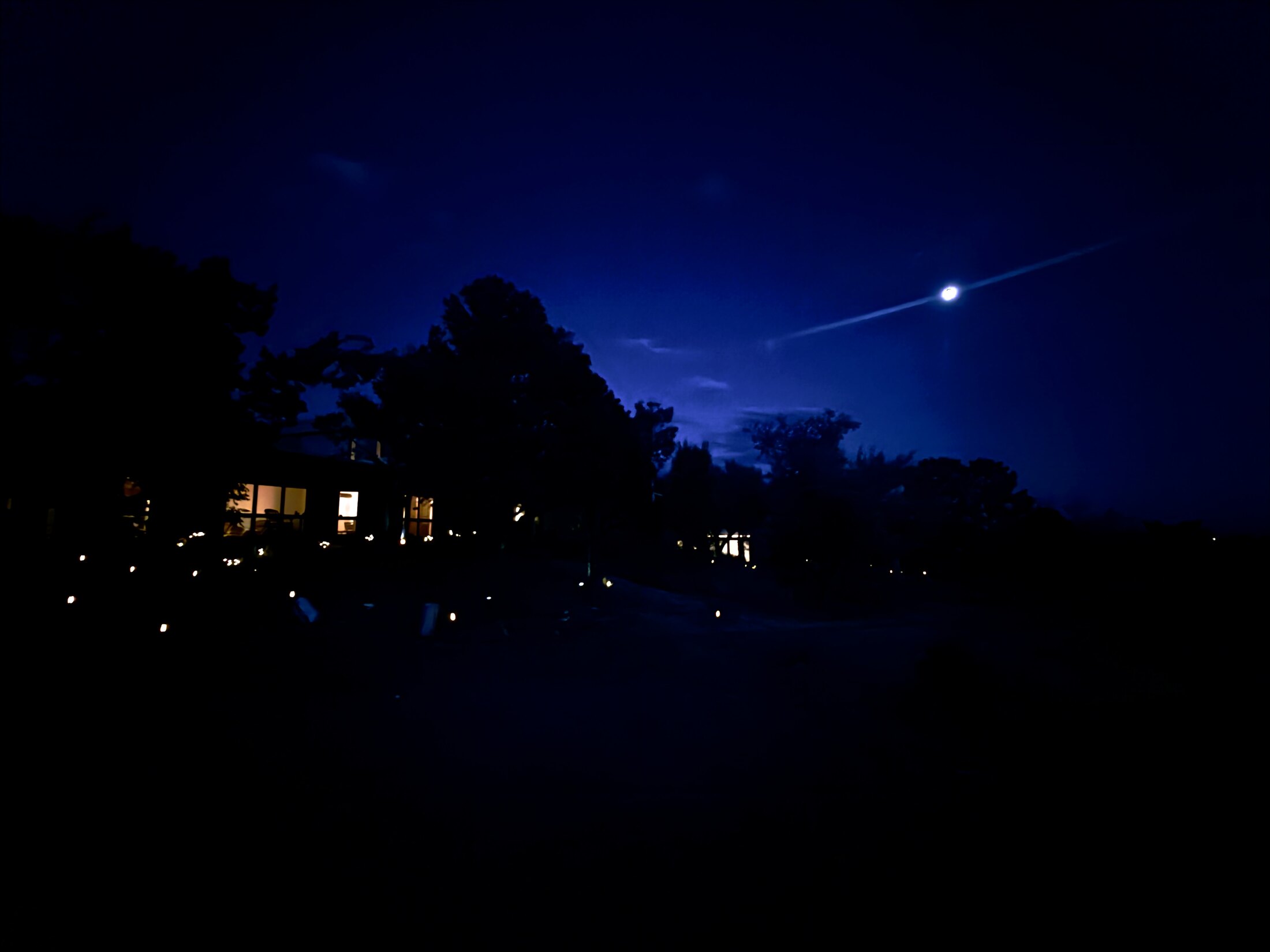 The ranch house glowing beneath a deep blue moonlit sky
